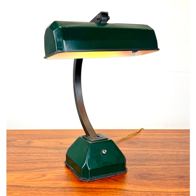 A vintage art deco style desk or banker’s lamp circa 1940’s featuring a heavy adjustable bronze arm and tilting shade....