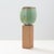 An ovoid vase with green glaze on tall stone base by Stig Lindberg Sweden, 1930s An ovoid vase with green glaze on tall...