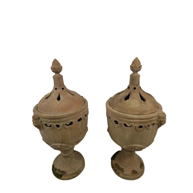 A pair of terracotta orangerie stoves, Italy, 19th century. Each stands on a round foot and a turned stem. The body...