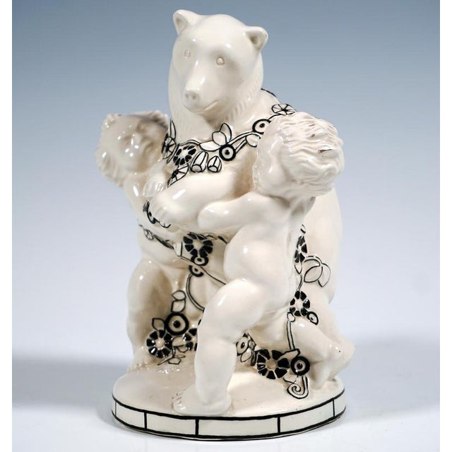 Excellent art nouveau ceramic piece in a rare version: two naked cherubs holding a bear standing upright between them,...