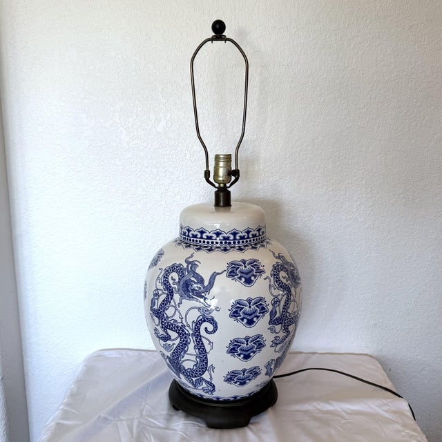 Large-scale blue and white Chinoiserie table lamp with dragon motif. It is a converted ginger jar. It measures 29" tall x...