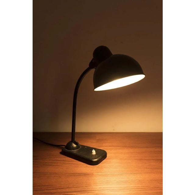 An attractive black desk lamp. The desk lamp has a small dent on the hood but is still is in good vintage condition....