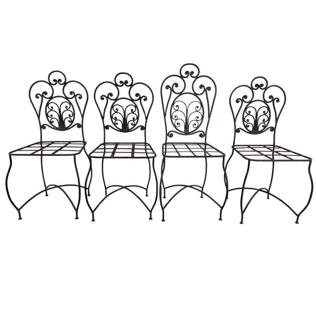 Magnificent set of 4 wrought iron chairs from the 70s. Handcrafted work from the south of France, one of the chairs is...