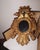 A richly carved antique European giltwood wall mirror featuring a crowned double eagle crest above an oval mirror plate....