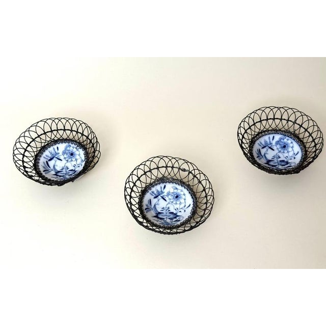 A rare and charming set of three antique porcelain and handcrafted wire bowls, Germany, second half of the 19th century,...
