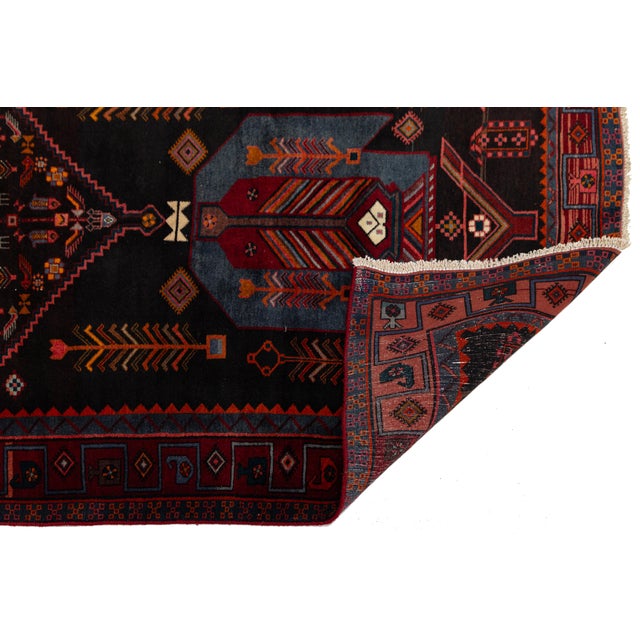Hand-knotted with hand-spun wool, this authentic vintage Kurdish runner showcases rich tribal iconography and geometric...