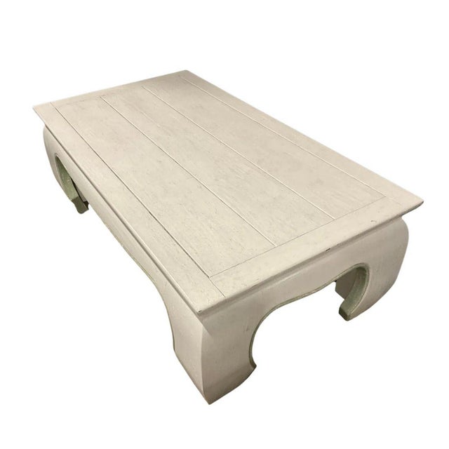 A painted wood white coffee table in white finish with ming style legs and a touch of light green accenting the trim. The...