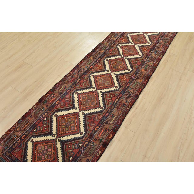 This authentic, vintage Hamedan tribal runner is hand-knotted with fine wool and natural dyes. This nomadic oriental rug...