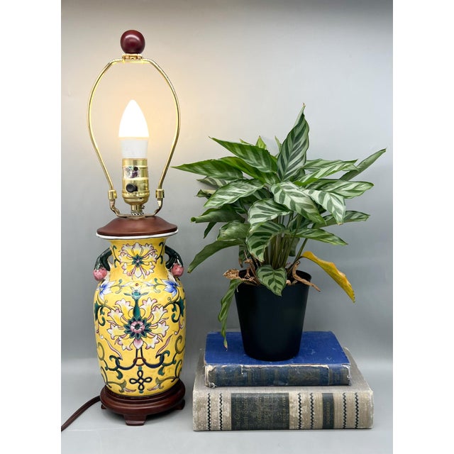 Charming vintage Chinese porcelain table lamp with a vibrant yellow background, hand-painted scrolling foliage, and...