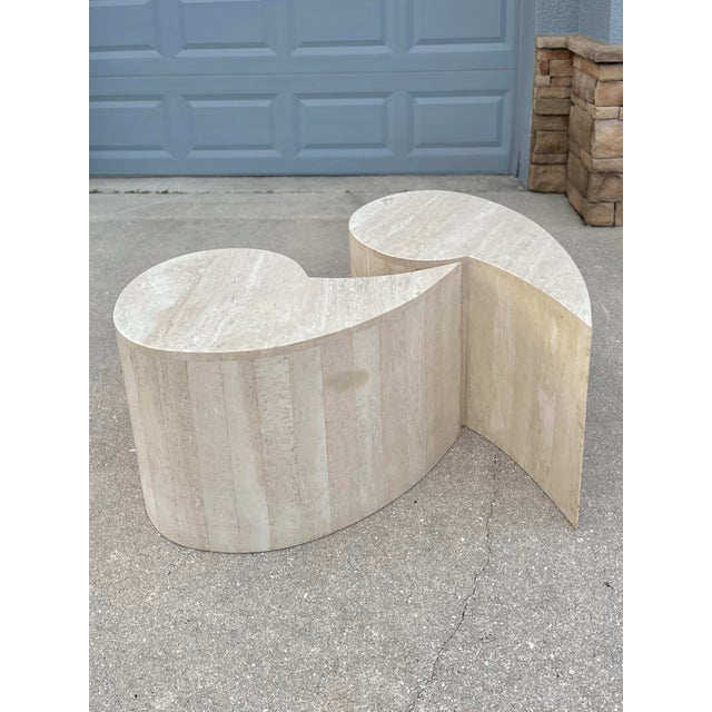 A Pair of Italian Modern Travertine Coffee Tables. This pair resembles the shape of single quotations. These can be paired...
