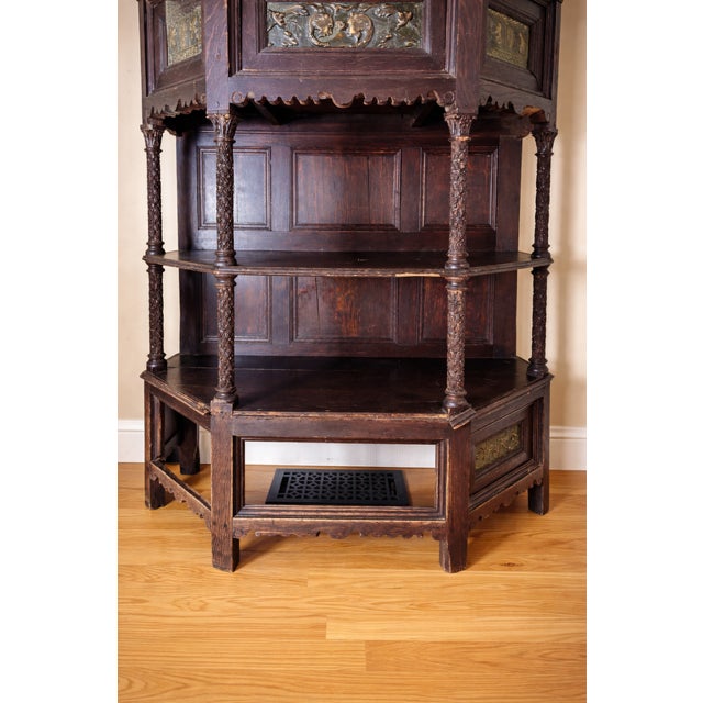 A striking Late 19th Century Gothic Revival oak cabinet featuring richly carved architectural detailing and repoussé metal...