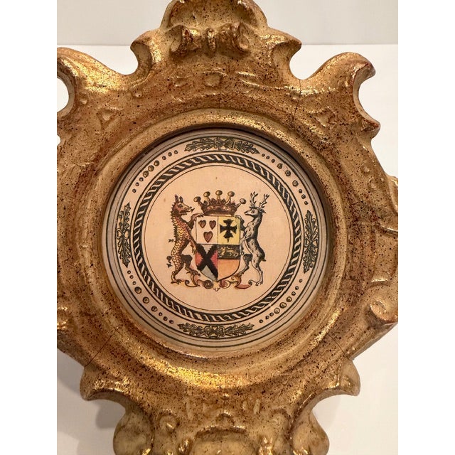 Stylish regal pair of small gilded plaster plaques having crested lion prints inside.