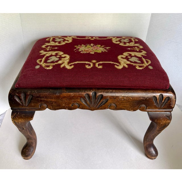 This charming antique English footstool features a beautifully carved wooden frame supported by graceful cabriole legs and...