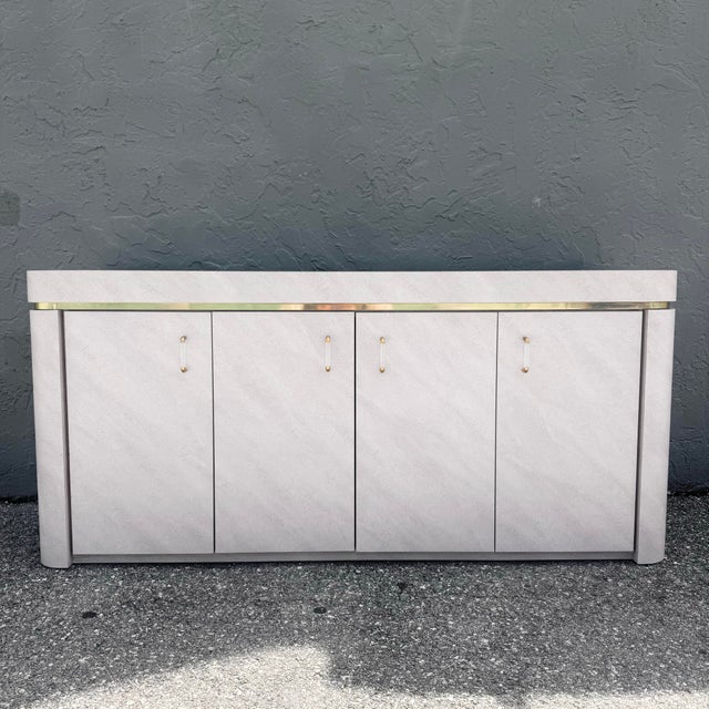 A striking postmodern credenza that exudes refined sophistication through its sculptural silhouette, soft lavender-toned...