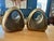 Ben Seibel Orb bookends in brass. Pair of rounded sculptural brass over white metal bookends with cutout handles. The warm...