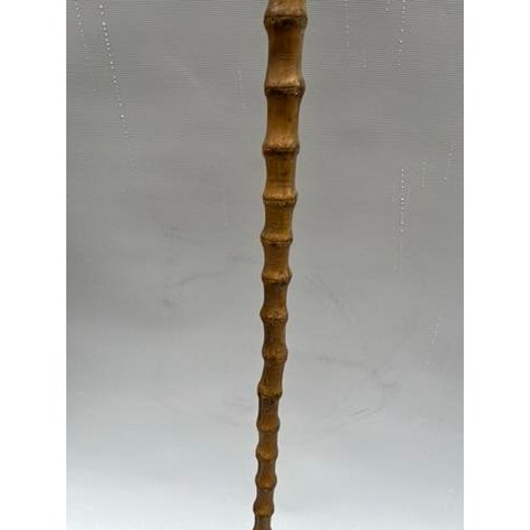 A single antique bamboo walking stick or cane with metal tip.