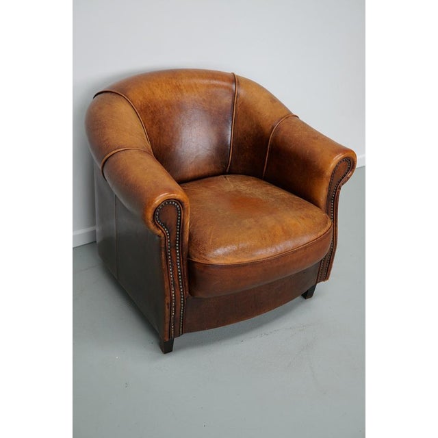 This cognac-colored leather club chair comes from the Netherlands. It is upholstered with cognac-colored leather and...