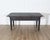 A handsome Swedish country kitchen table crafted from solid pine and finished in a worn, matte black paint that highlights...