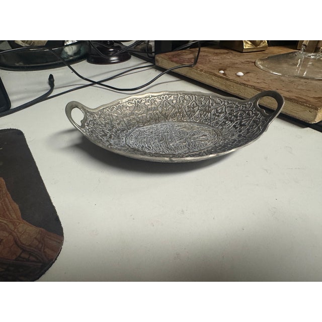 Shop a vintage decorative oval metal dish with dual handles, intricate embossed detailing, and antique silver finish at...
