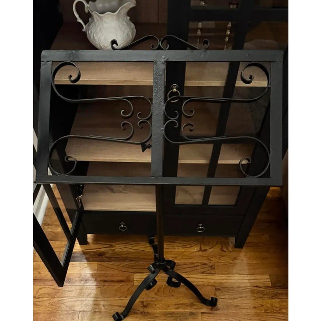 Substantial and beautifully balanced, this mid-century hand-forged wrought-iron music stand features intricate scrollwork...