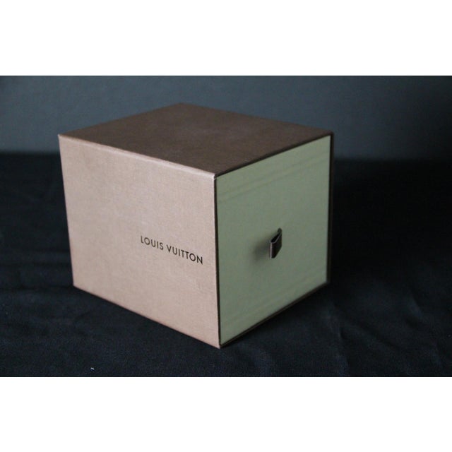 A rare and highly sought-after louis vuitton decorative object, this piece comprises an intricate miniature travel trunk...