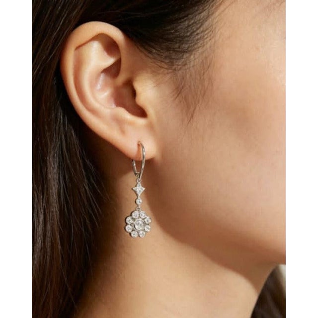 Elegant 14K white gold dangle earrings featuring a floral-inspired design with 12 brilliant round diamonds totaling 0.5...