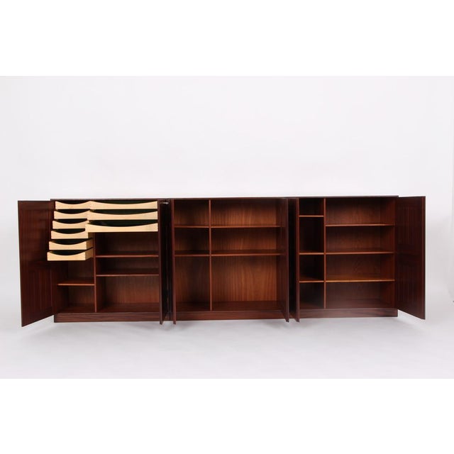 An arrangement consisting of 3 base cabinets in dark mahogany, divided with adjustable shelves, picture room shelves and...