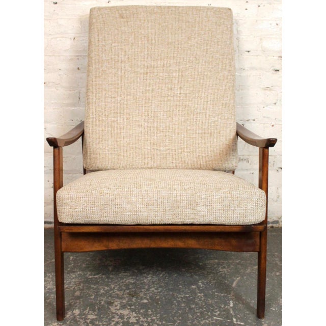 Mid-Century Modern walnut high-back lounge chair featuring a sculptural walnut frame and elegant, clean lines. Newly...