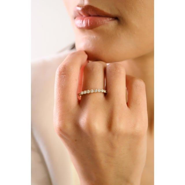 This elegant half eternity band ring features a 11 round brilliant-cut diamonds totaling 0.69 carats, beautifully set in...