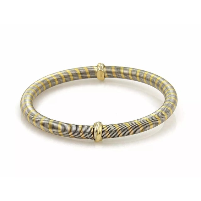 This gorgeous authentic vintage bangle is by Cartier, it is crafted from 18k yellow gold mixed with stainless steel set in...