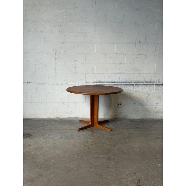 Beautiful vintage Danish mid-century modern dining table crafted in warm teak wood, featuring an elegant round tabletop...