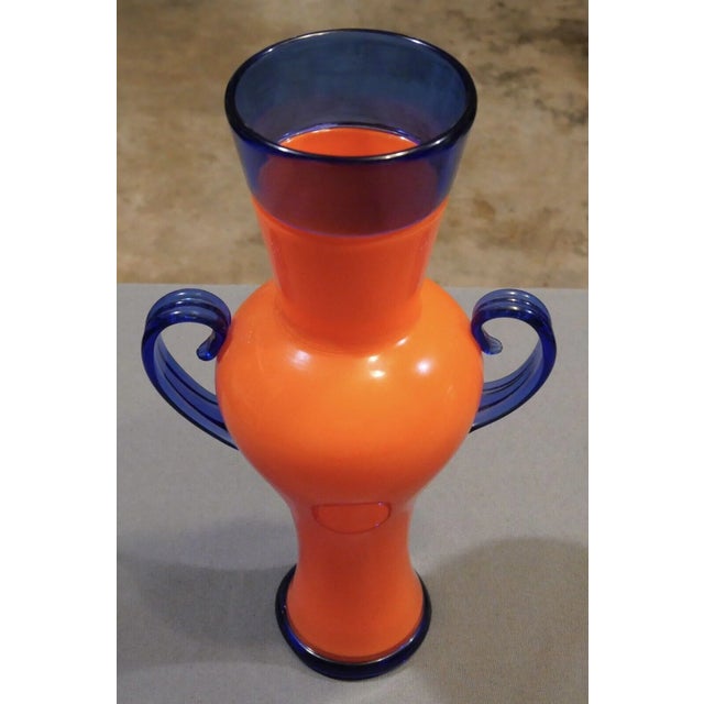 Up for sale is a 2001 Ipso Facto Art Glass Contemporary Style Orange/Blue Double Handled Vase! It measures 13 3/4” tall....