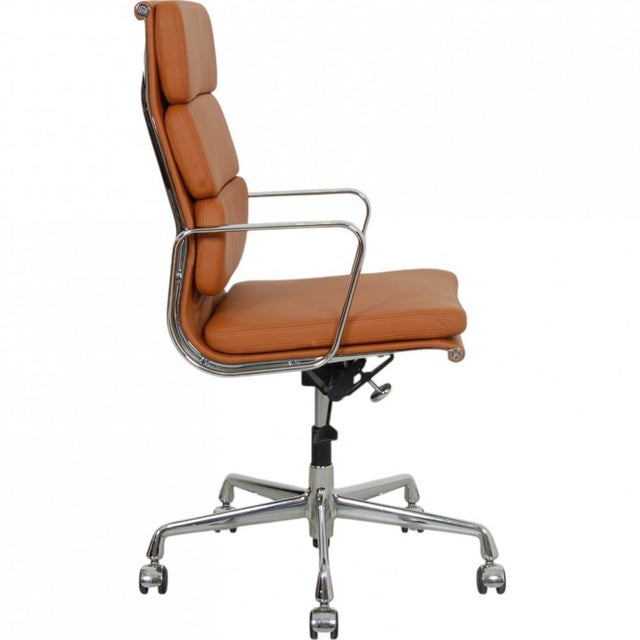 Charles Eames EA-219 softpad office chair with a tall back, upholstered in cognac bizon leather, and with chrome armrests...