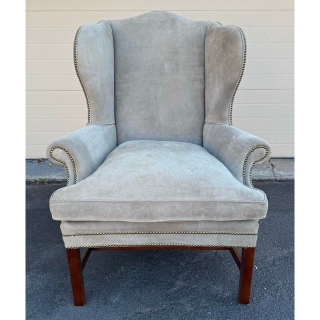 Ralph Lauren Devonshire chair in light beige suede with nailhead trim on mahogany legs with down seat cushion.