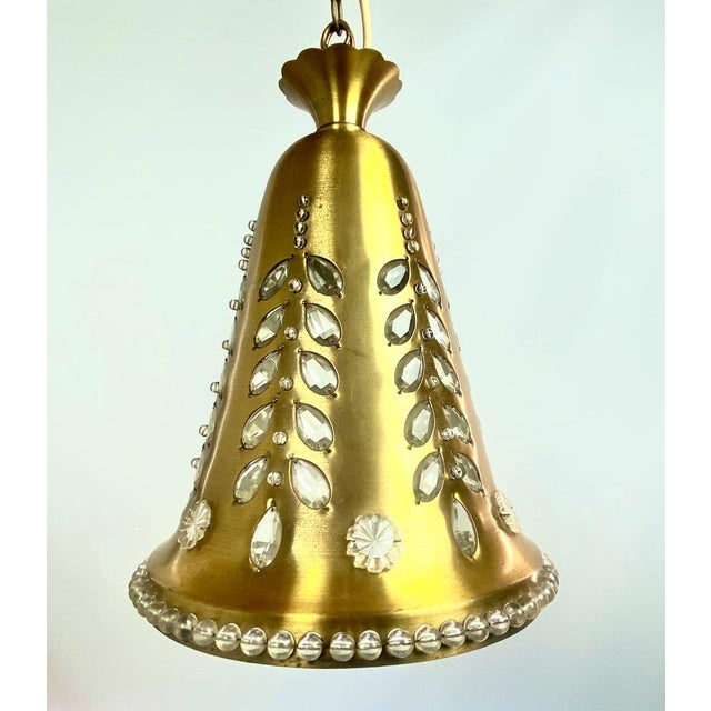 Special hanging lamp in the shape of a brass bell with crystals and a glass beaded edge. A refined and handmade item from...