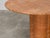 A round red travertine table attributed to Mario Bellini, dating from the 1970s. Its circular top with rounded edges rests...