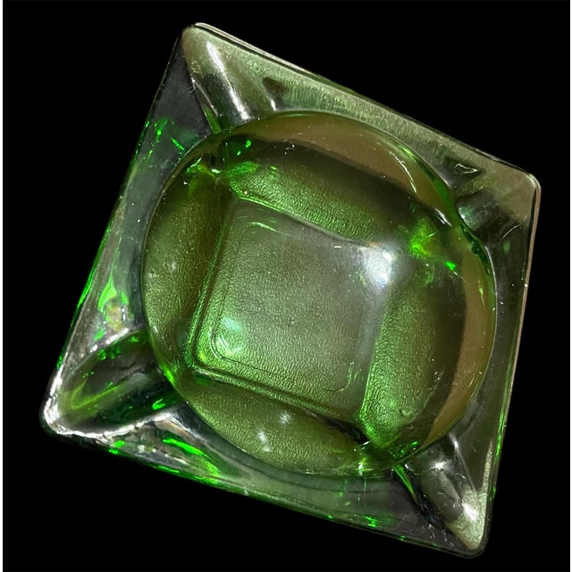 Beautiful green glass ashtray reminiscent of late 50’s early 60’s. Sits on square bottom base with 4 butt rest. Repurpose...