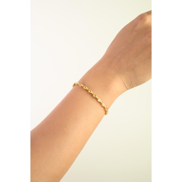 This elegant tennis bracelet features 25 oval cut natural yellow sapphires totaling 7.56 carats, set in 14k yellow gold....
