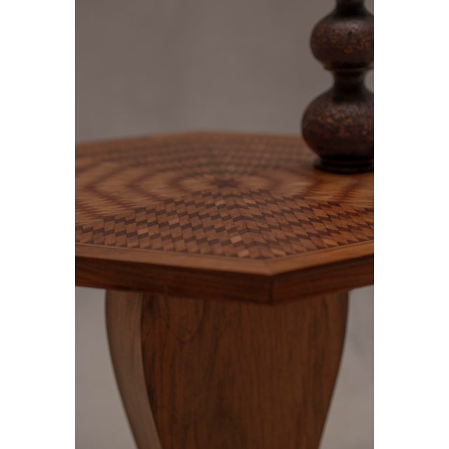 Elegant mid-century side table featuring a striking octagonal silhouette and an intricately crafted marquetry tabletop....