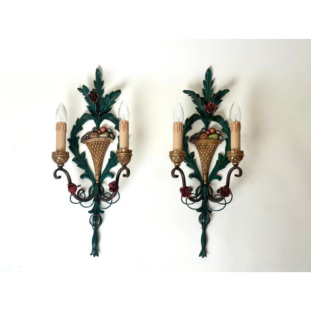 This striking pair of two-light wall sconces beautifully embodies the opulent elegance of the hollywood regency style,...