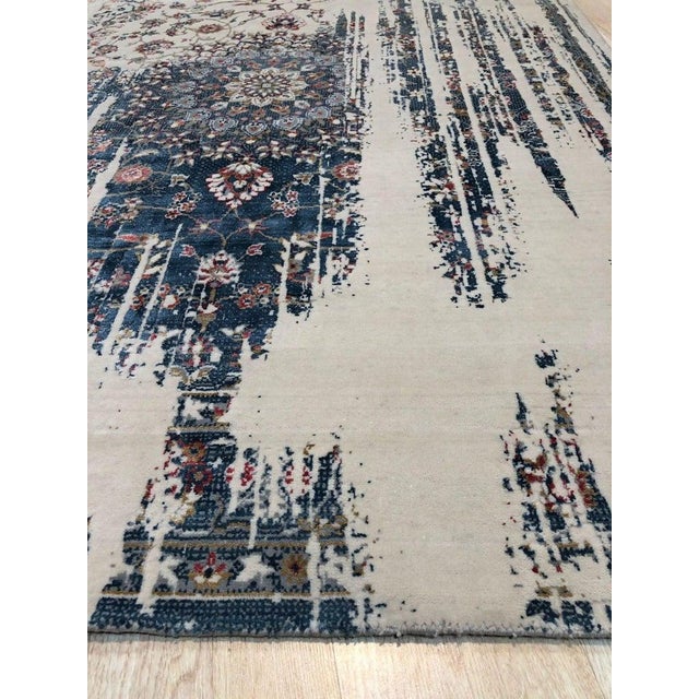 This machine-made area rug features a primary color palette of ivory, beige, cream, and white. Composed of a blend of wool...