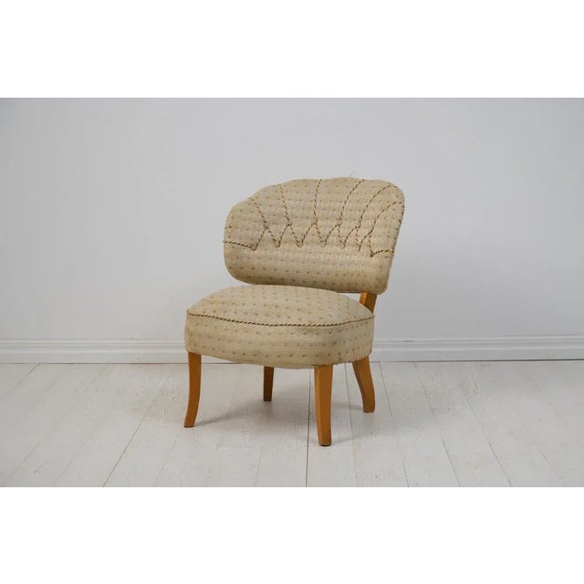 Swedish Carl Malmsten armchair 'Gamla Berlin' from the 1940s. The chair has a frame in birch with a curved and padded back...