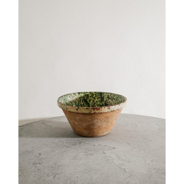 A rare Danish antique and oversized stoneware bowl in teracotta with a white green glazed inside and an old and decorative...