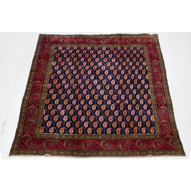 This hand-knotted vintage Shiraz rug is made of wool. The navy blue field features a captivating all-over Boteh pattern in...