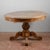 This splendid oval extendable table, veneered in walnut with a carved central leg and crafted from solid walnut, is an...