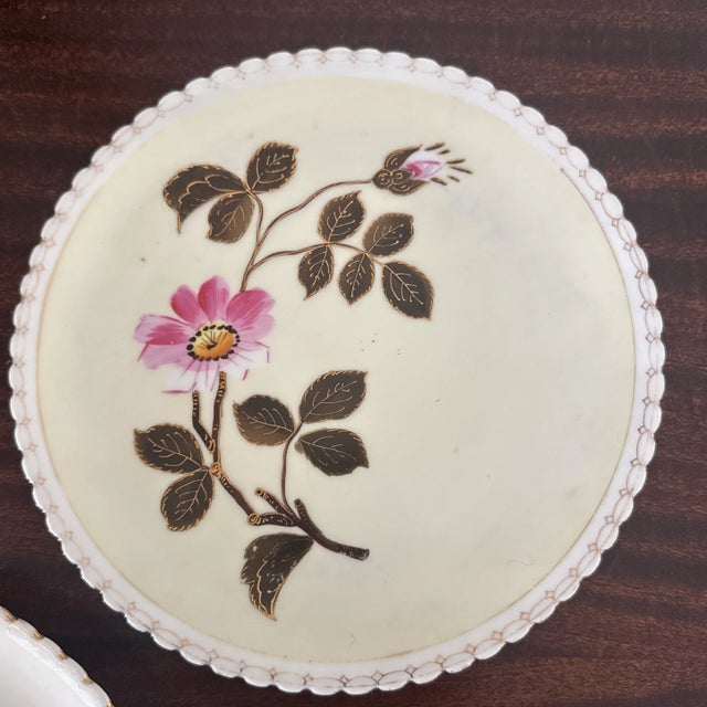 Listing is for a pair of antique porcelain plates. Each is hand decorated with a pink flower and the scalloped rim has a...