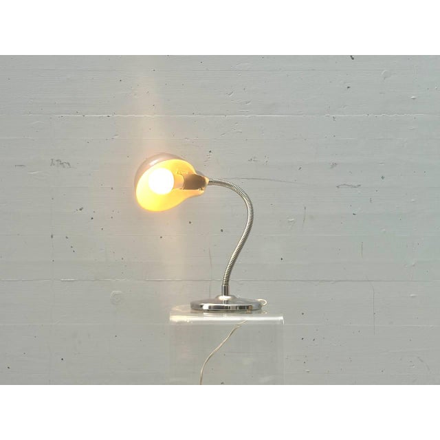 This distinctive table lamp embodies the functional yet elegant design approach of the 1960s. Crafted from chrome-plated...