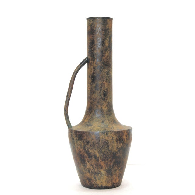 This metal vase features a sculptural silhouette and a weathered bronze finish that adds warmth and character. Its unique...