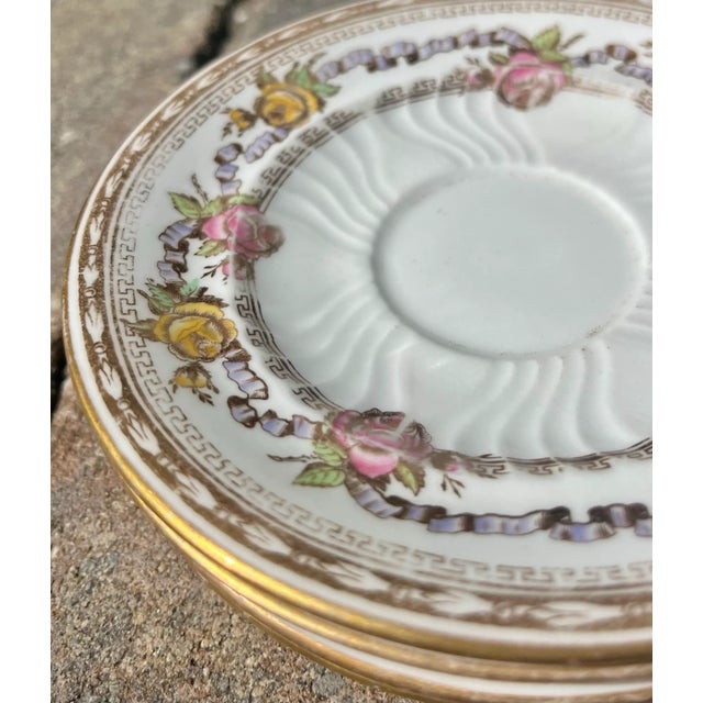 (4) Antique saucer plates with garland of yellow and pink roses trimmed in gold. *Acquired from the formerly Packwood...