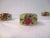 Lovely set of eight hand-painted ceramic napkin holders. Soft green background featuring a raised fruit and floral motif...